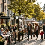 Oudere koppel drinkt koffee op terras langs Nederlandse gracht met voorbijgangers, fietsen en traditionele gevels