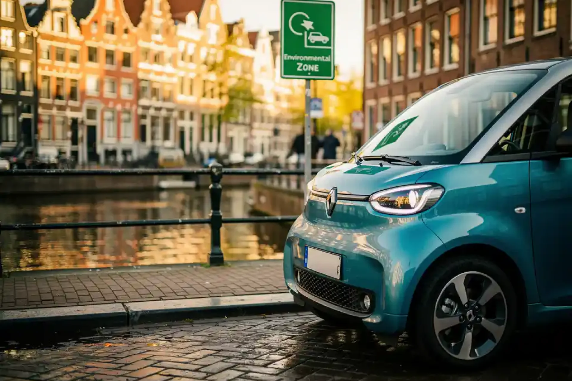 Elektrische stadsauto geparkeerd bij Amsterdamse grachtenbrug met groene milieuzonebordes, smalle klinkerstraat en weerspiegeling van grachtenpanden.