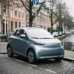 Compacte elektrische stadsauto geparkeerd in smalle straat in Den Haag, met grachtenpanden en kale bomen op de achtergrond.